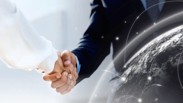 Two business people shaking hands in front of a dashboard, symbolizing partnership